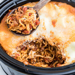 A serving spoon has removed a scoop of spaghetti from the Crockpot.