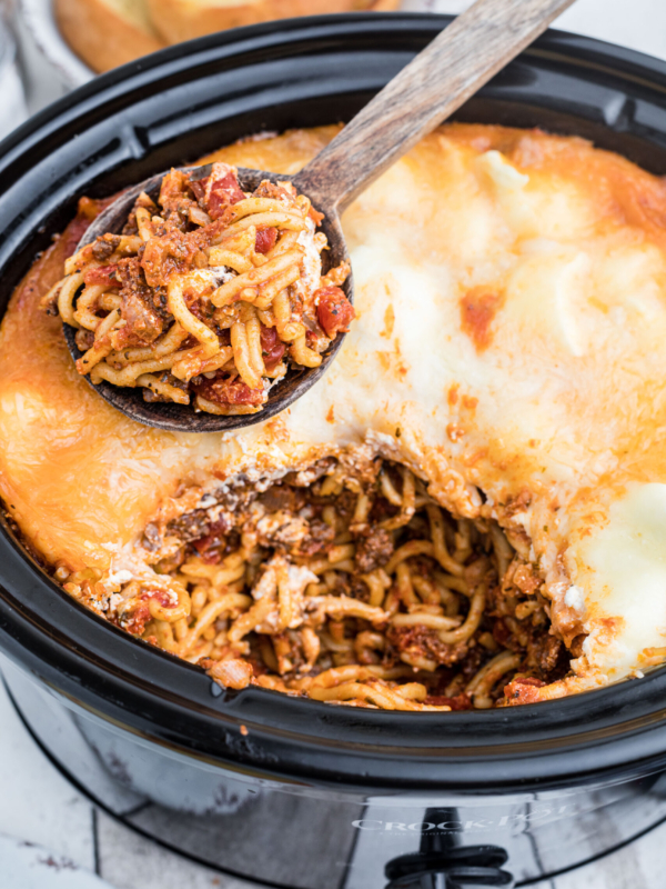 A serving spoon has removed a scoop of spaghetti from the Crockpot.