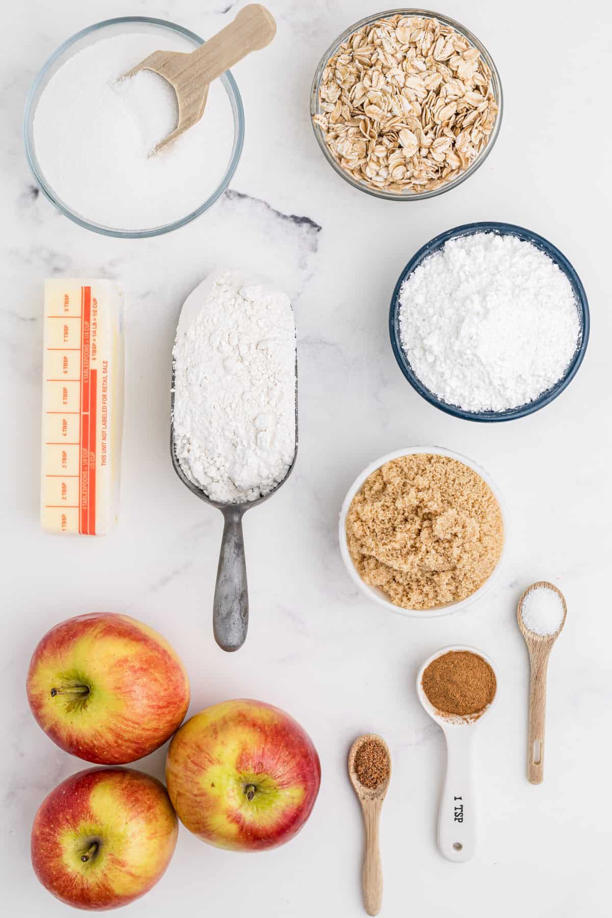 The ingredients for apple pie bars are placed on a white surface.