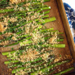 baked asparagus on a baking sheet with crispy panko topping.