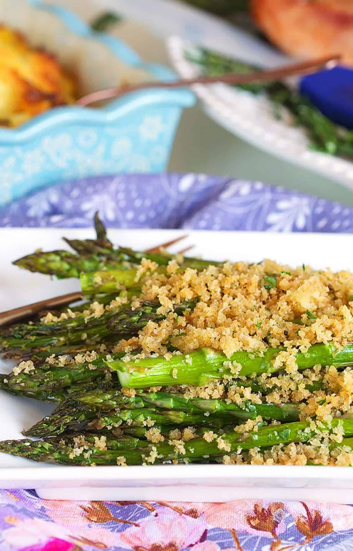 Baked asparagus with panko crust on a white platter.
