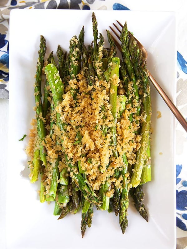 baked asparagus on a white platter.