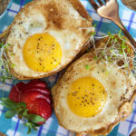 Two cooked eggs are presented on pieces of toast.