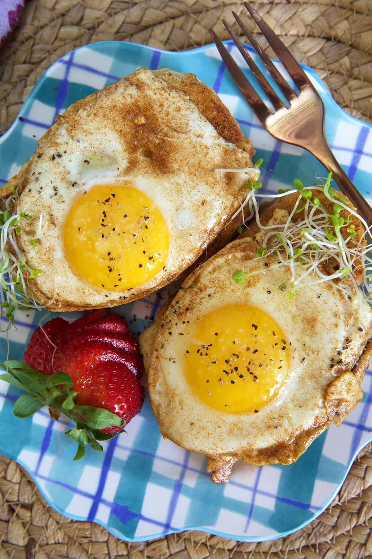 Two cooked eggs are presented on pieces of toast.