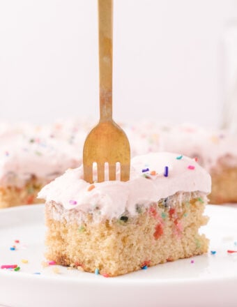 A fork is piercing a piece of cake.