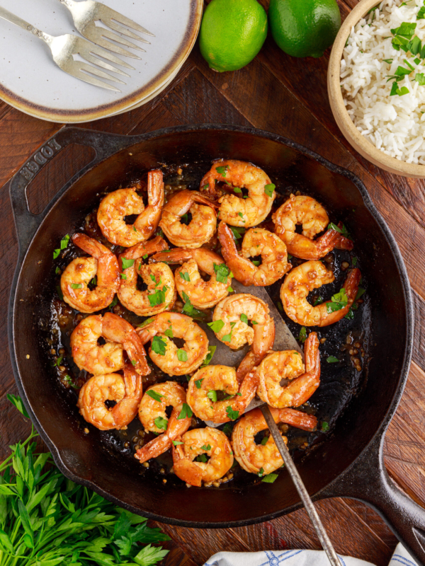 A black pan is filled with cooked shrimp.