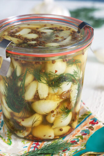 A jar is filled with pickled garlic and dill.