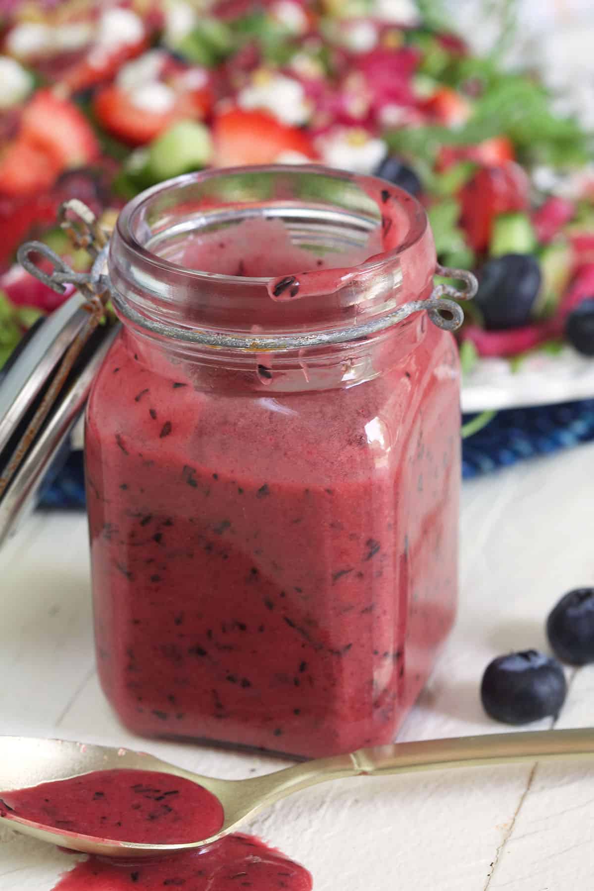 An open jar is filled with blueberry vinaigrette.