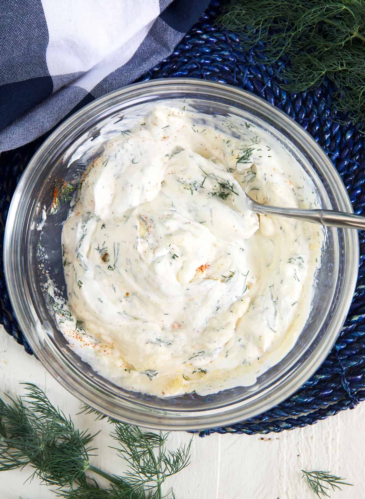 Dill dip has been mixed together in a glass bowl.