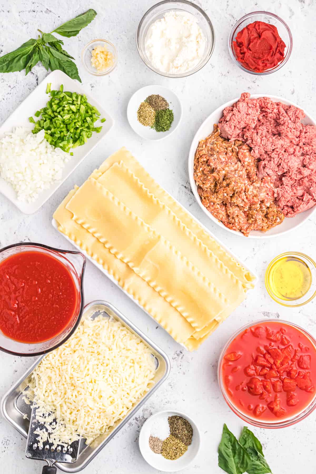 The ingredients for lasagna rollups are placed on a white surface.