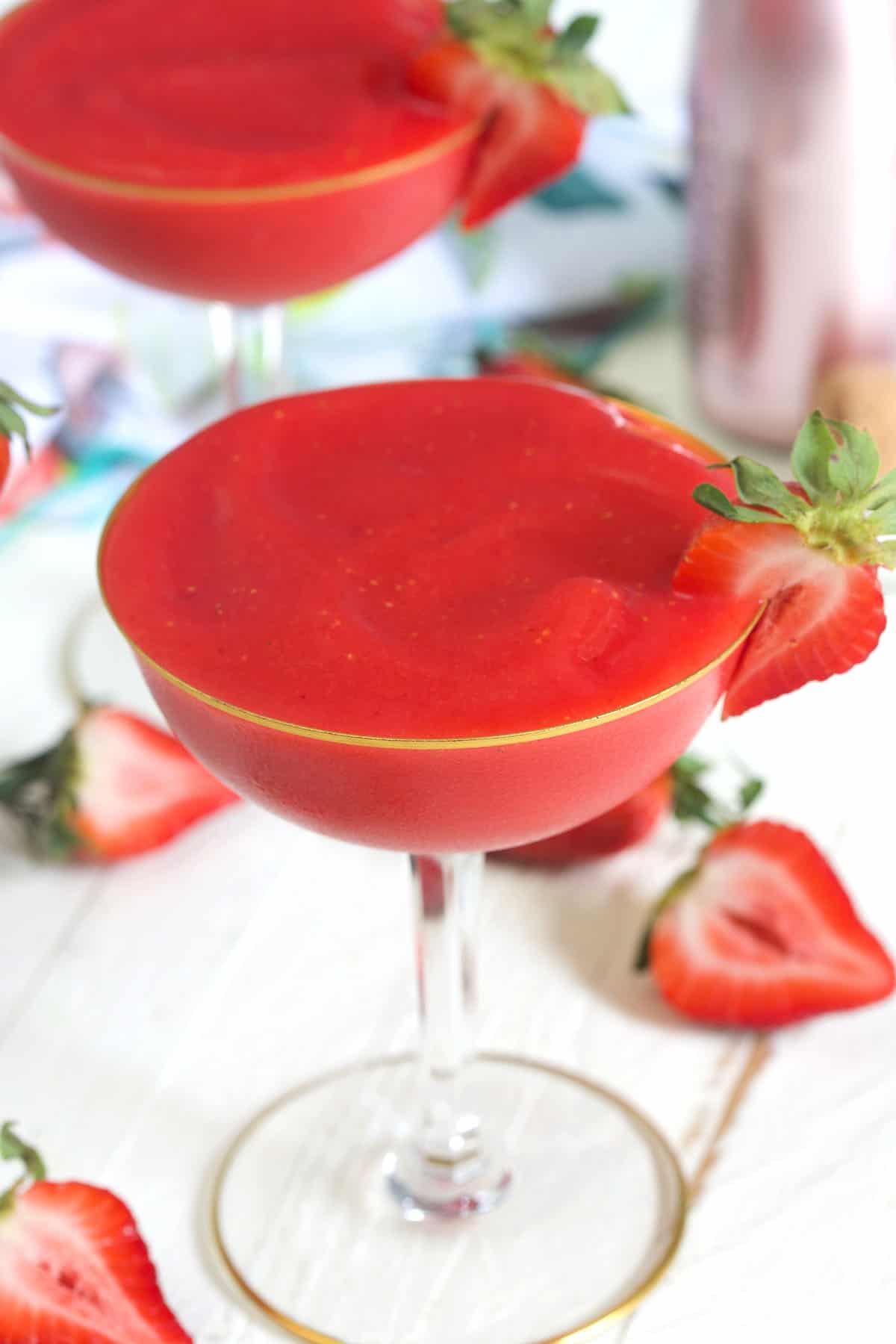 A glass of frose is garnished with a strawberry slice.