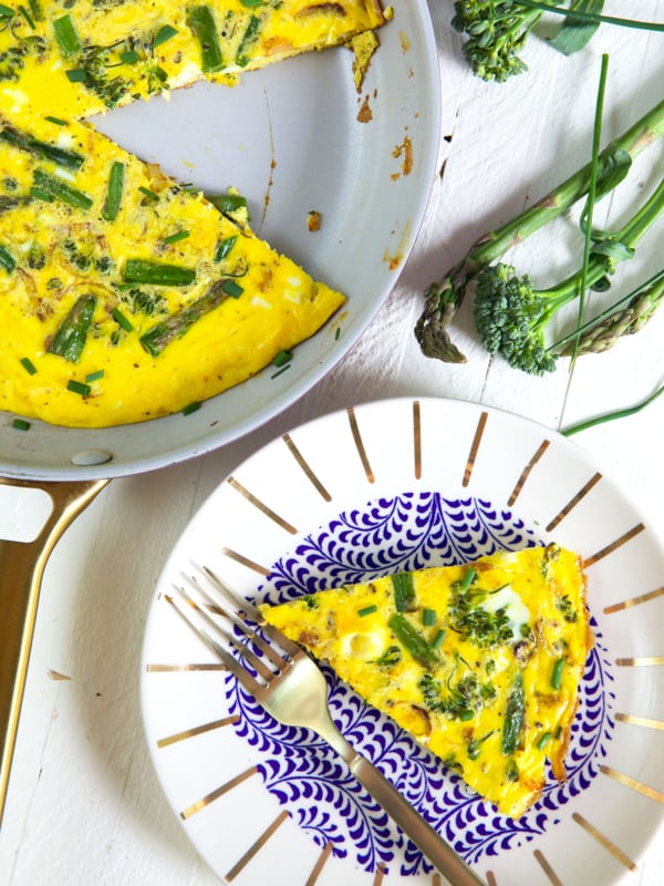 A slice of frittata is placed on a plate next to the pan.