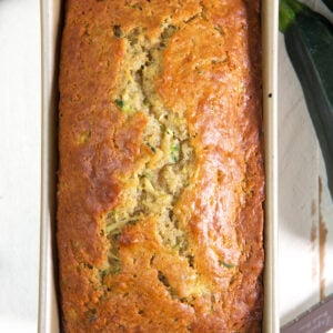 A loaf pan is filled with baked zucchini bread.