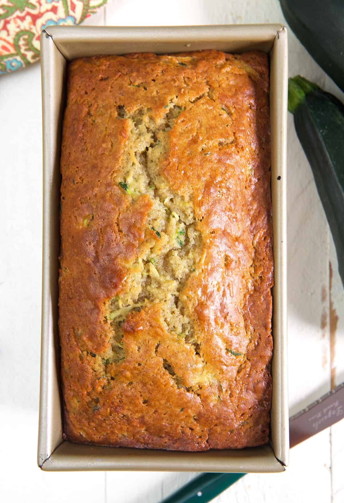 A loaf pan is filled with baked zucchini bread.