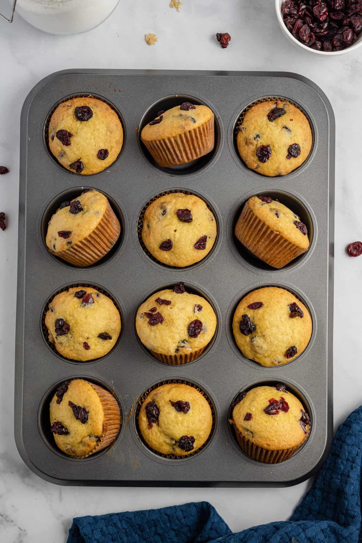 A dozen muffins are presented in a baking tin.