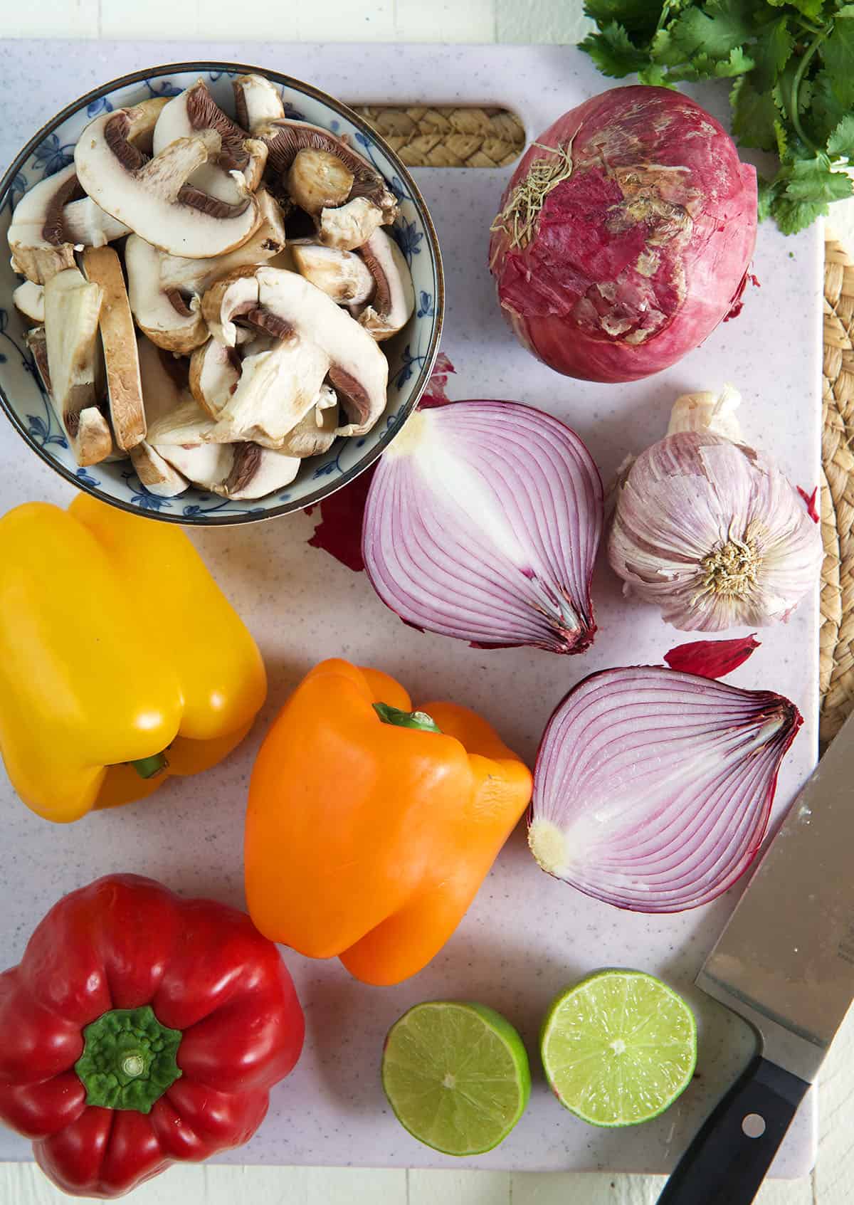 The ingredients for fajita veggies are presented on a cutting board.