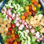 The ingredients for fattoush salad are all placed in a large salad bowl, but are not tossed together.