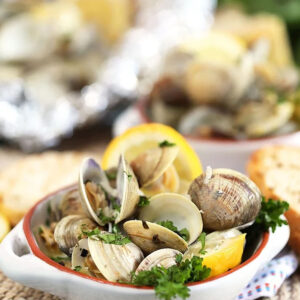 Grilled Clams with basil and lemons in a white ramekin