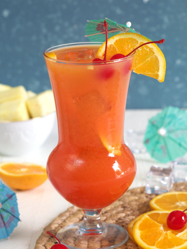 A garnished hurricane is placed on a placemat.