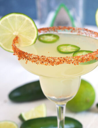 A margarita is topped with jalapeno slices and a lime round.