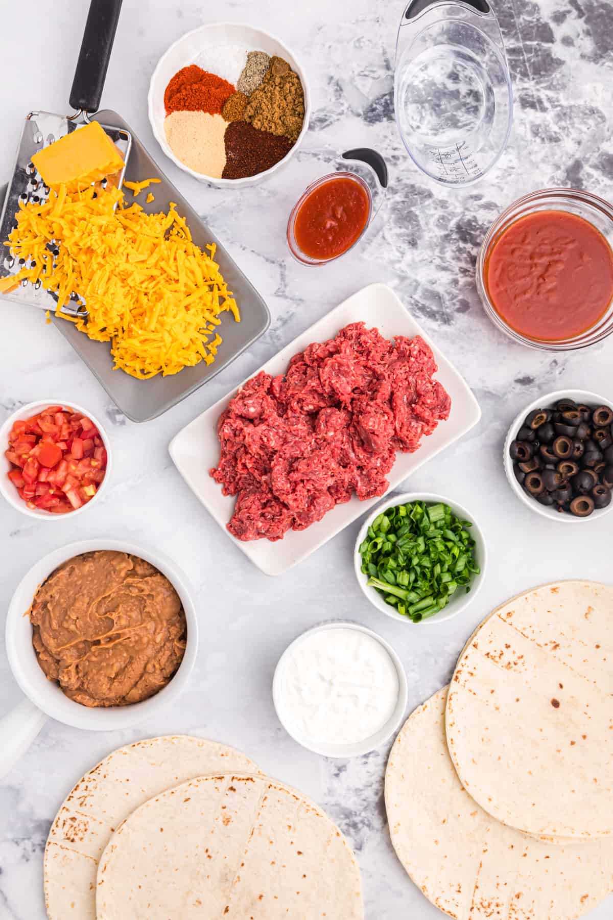 The ingredients for taco bell pizza are spread out on a countertop. 