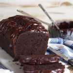 Double Chocolate Banana bread with a pot of chocolate glaze in the background.