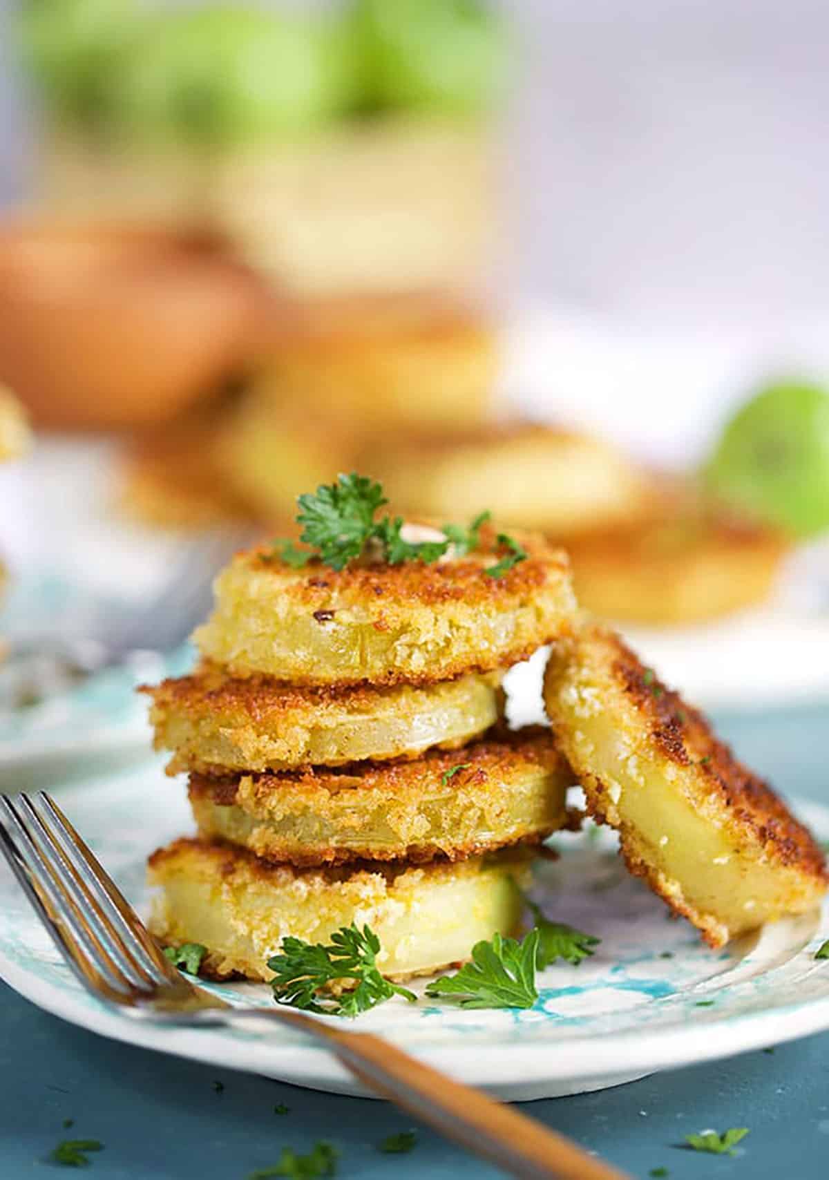 Stack of fried green tomatoes with a wooden fork 
