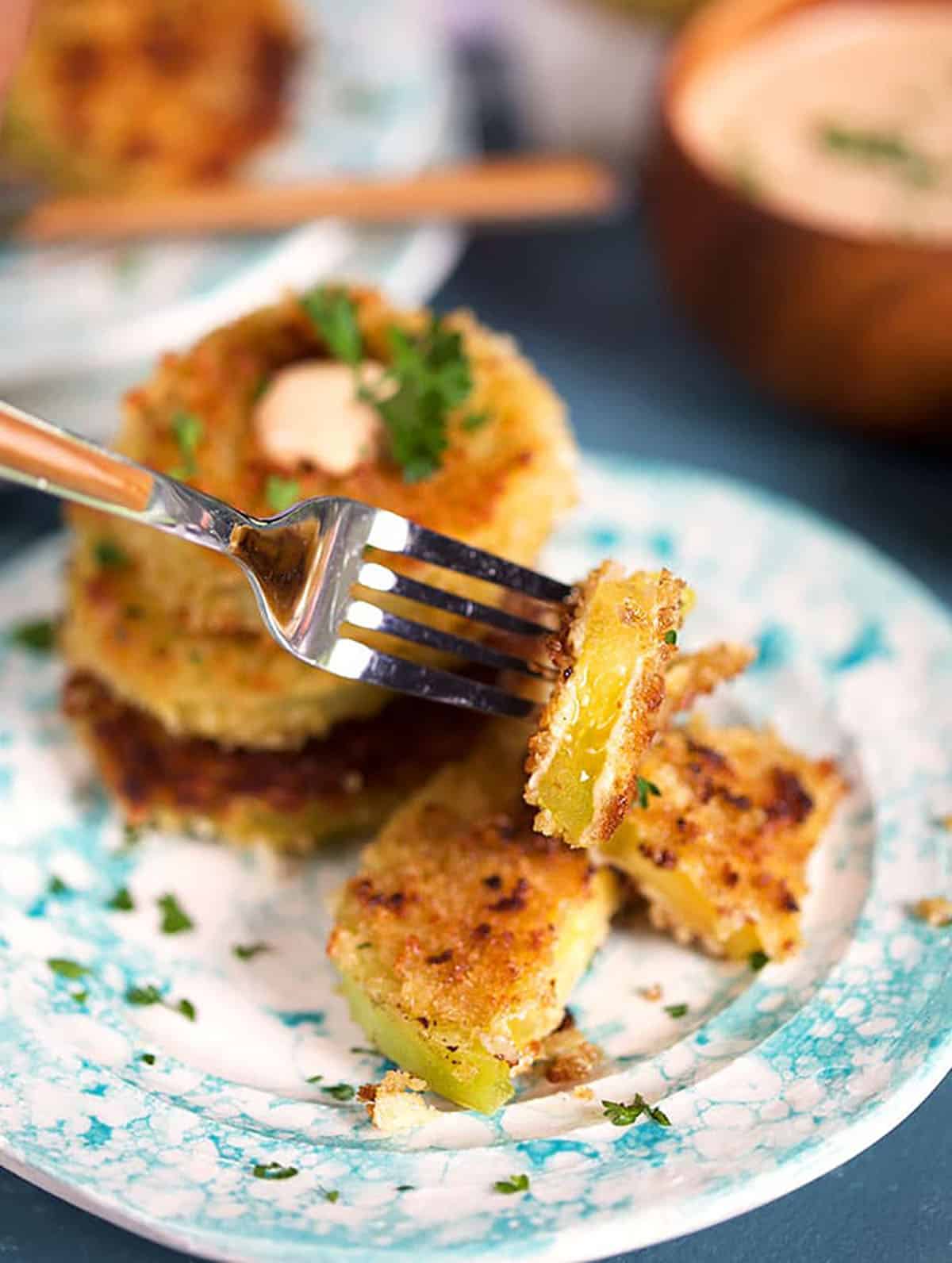 Fried Green tomatoes with a bite taken on a fork 
