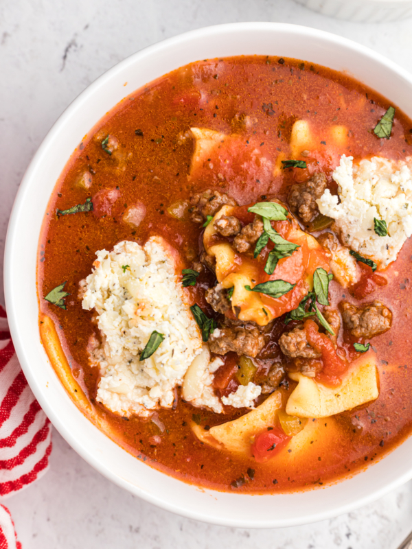 A white bowl of lasagana soup is filled to the top.