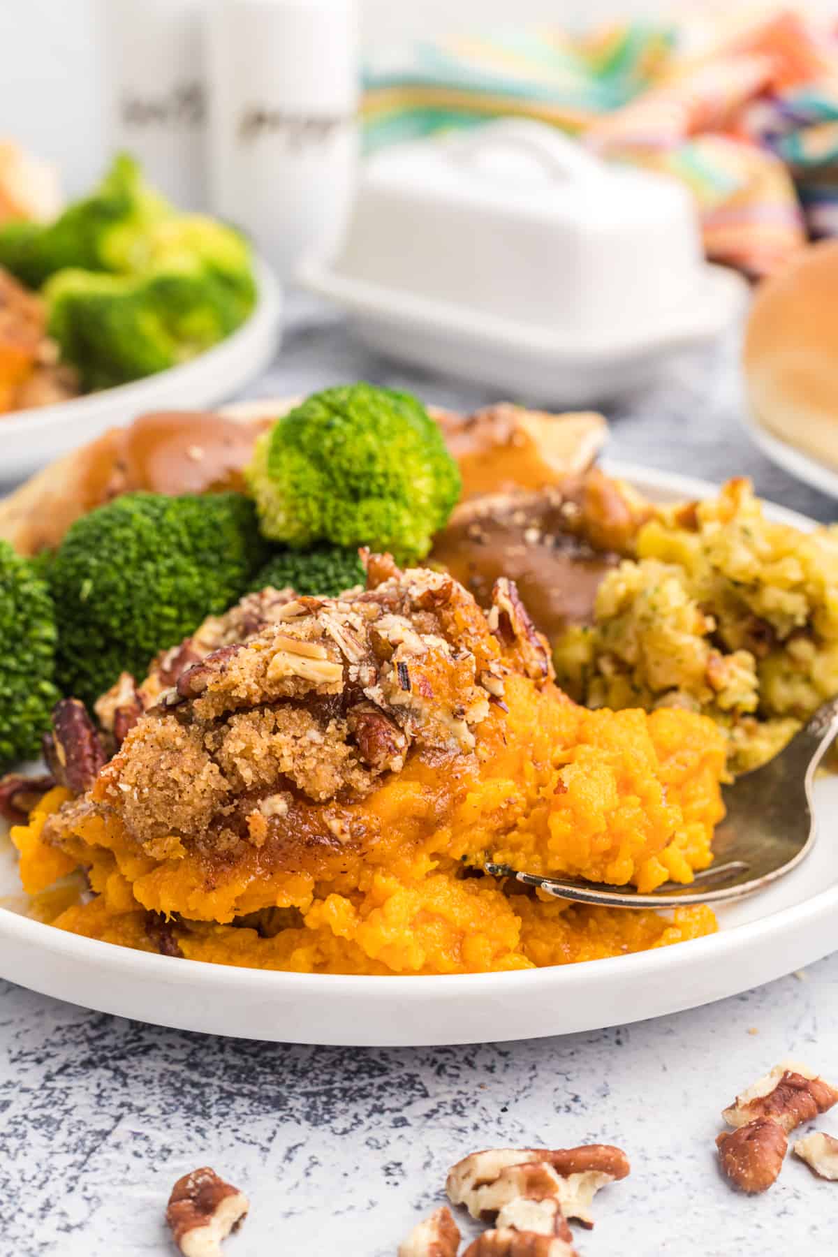 Sweet potato souffle and broccoli are placed on a white plate.