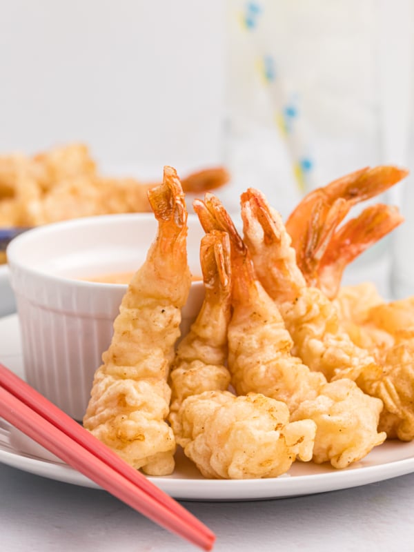 Several fried shrimp are placed next to dipping sauce.