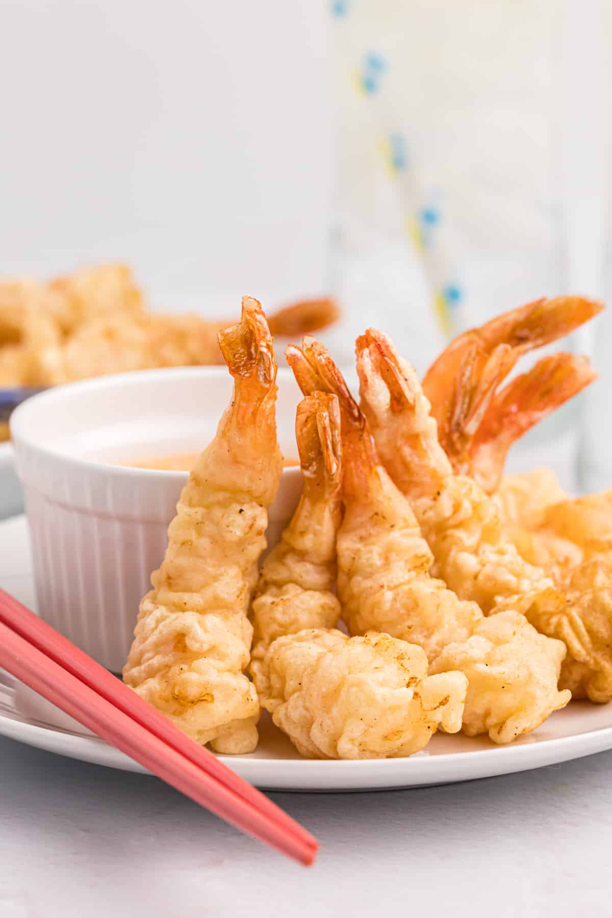 Several fried shrimp are placed next to dipping sauce.