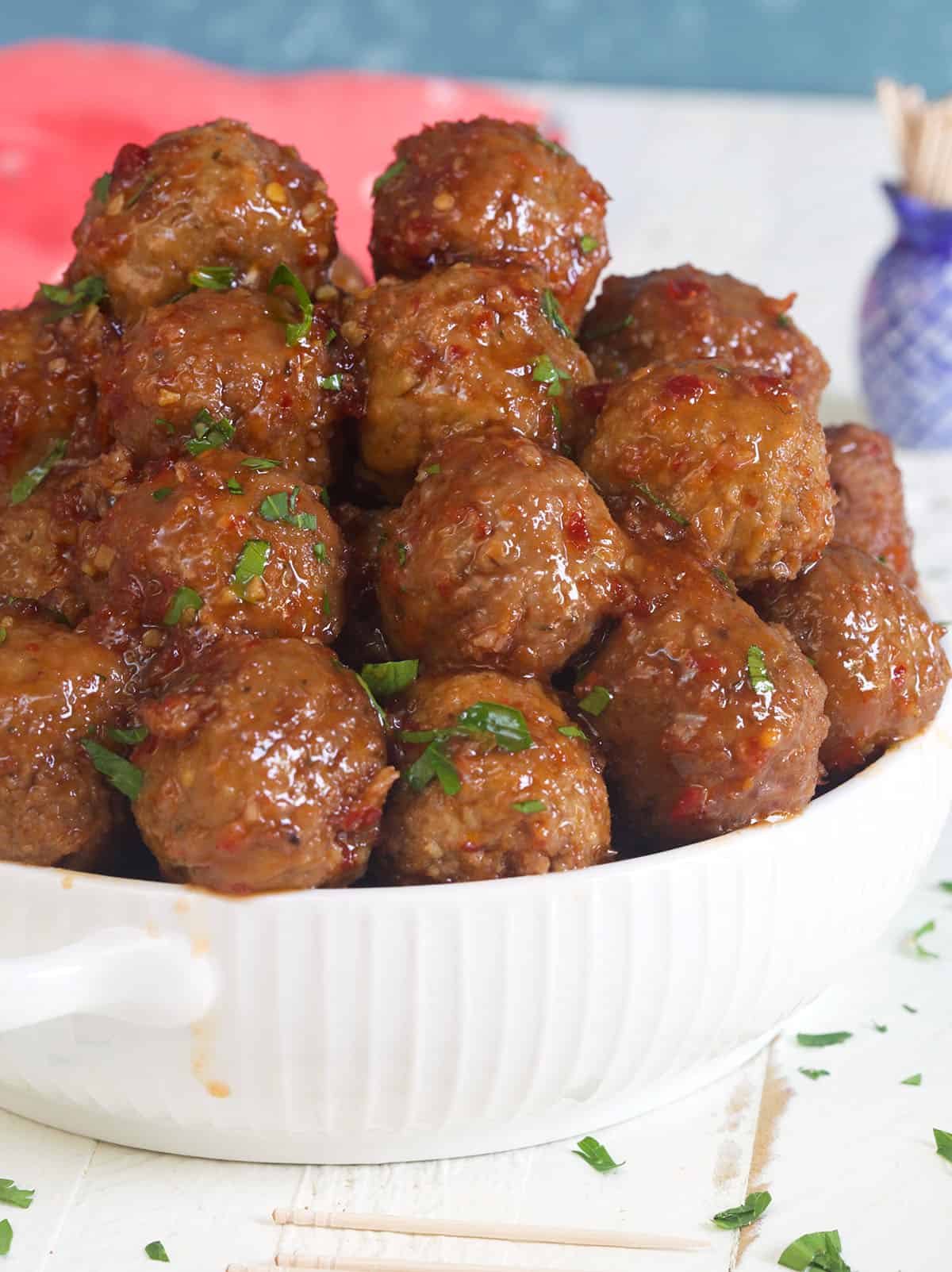A white bowl is filled with cooked meatballs.