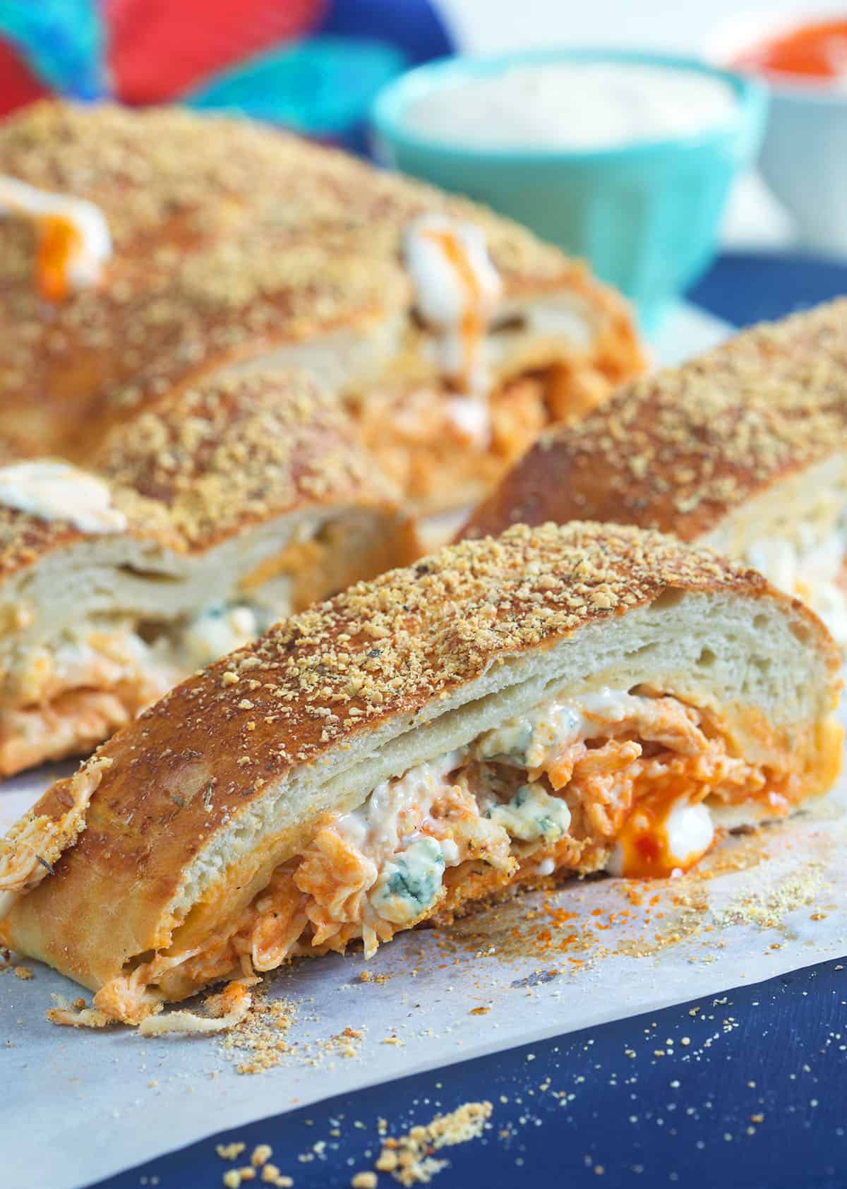 Slices of stromboli are placed on a sheet of parchment paper.