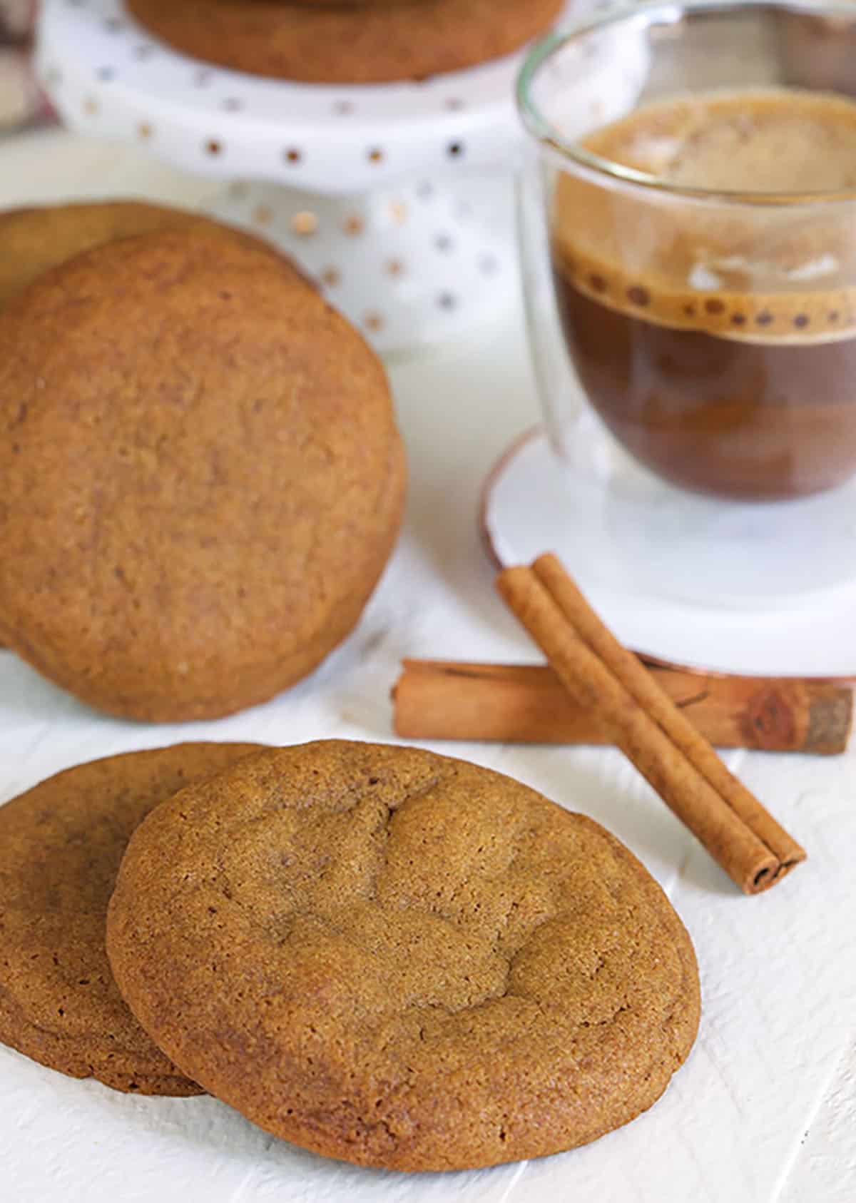 Gingersnap Cookies with a cup of coffee and two cinnamon sticks.