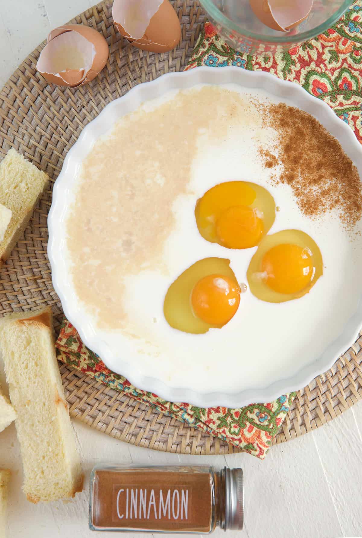 A white bowl is filled with eggs and seasonings.