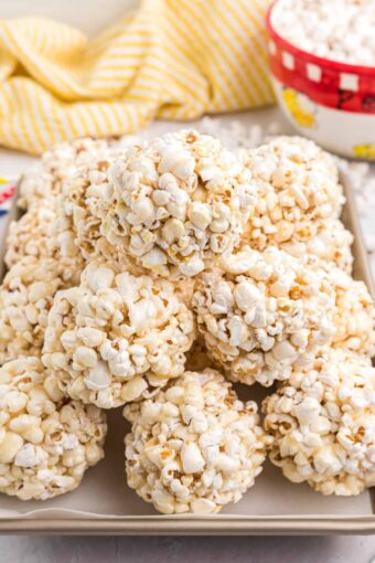 A pile of popcorn balls is presented on a tray.