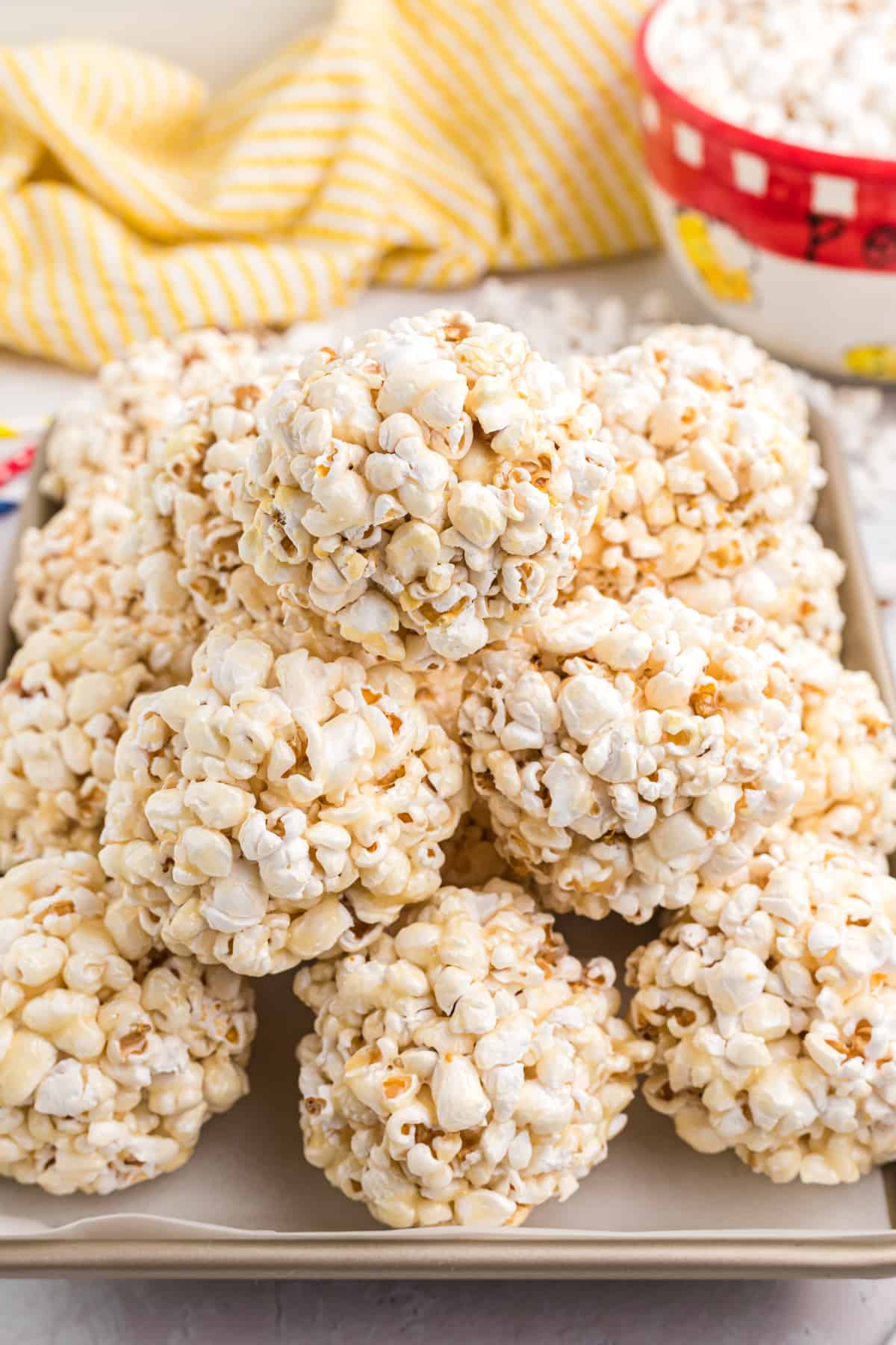 A pile of popcorn balls is presented on a tray.