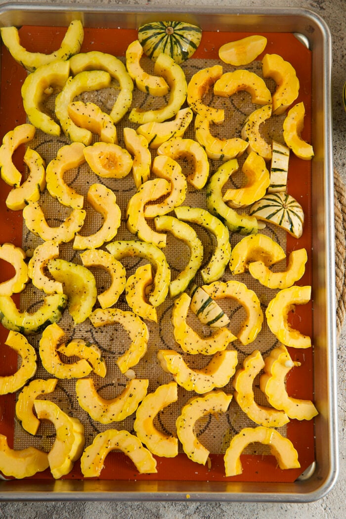 Seasoned squash on sheet pan before roasting