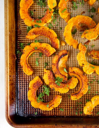 Overhead view of roasted delicata squash on a sheet pan