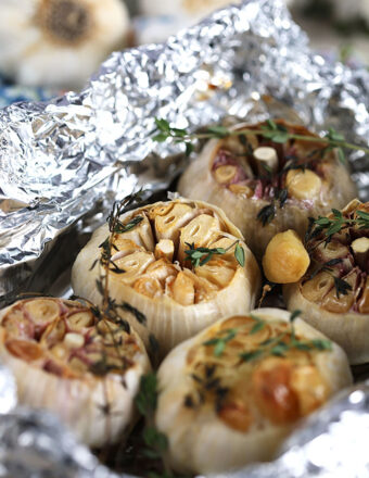 Roasted garlic in foil with thyme sprigs.