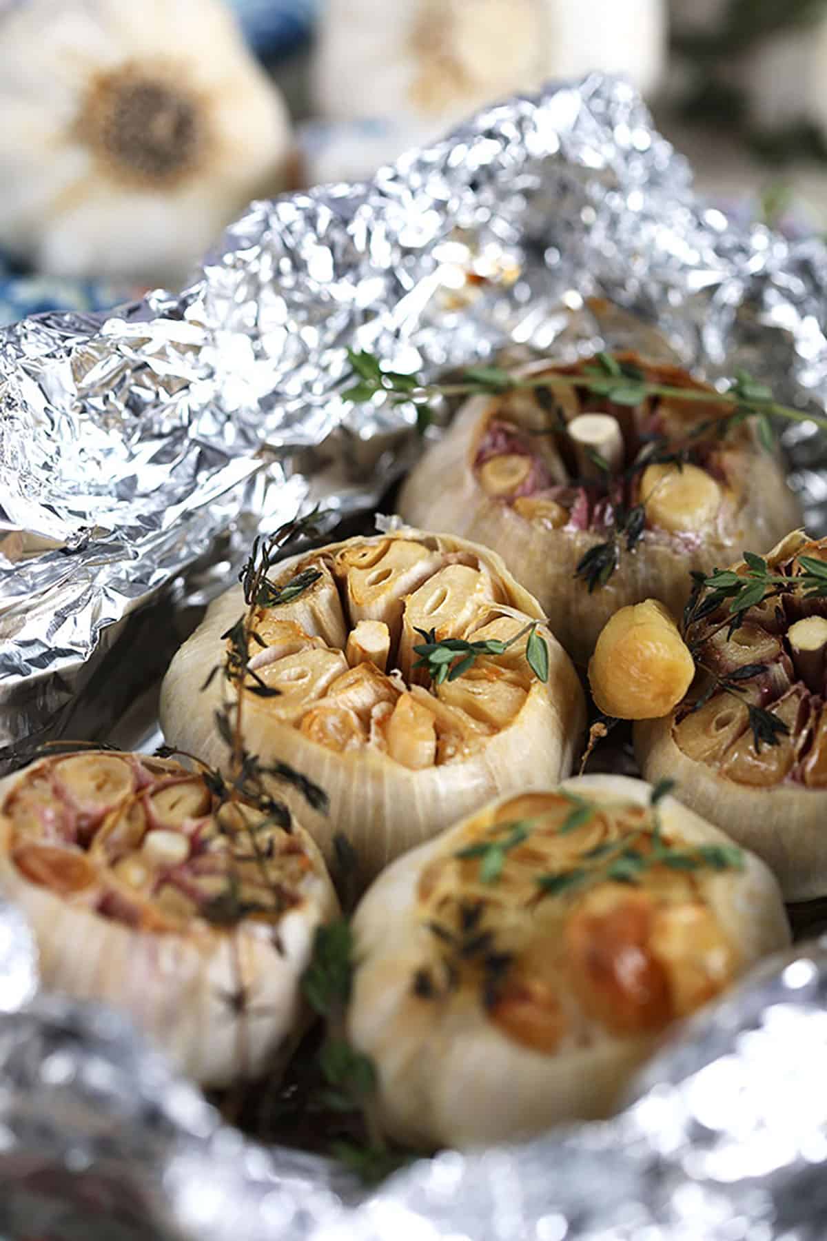Roasted garlic in foil with thyme sprigs.