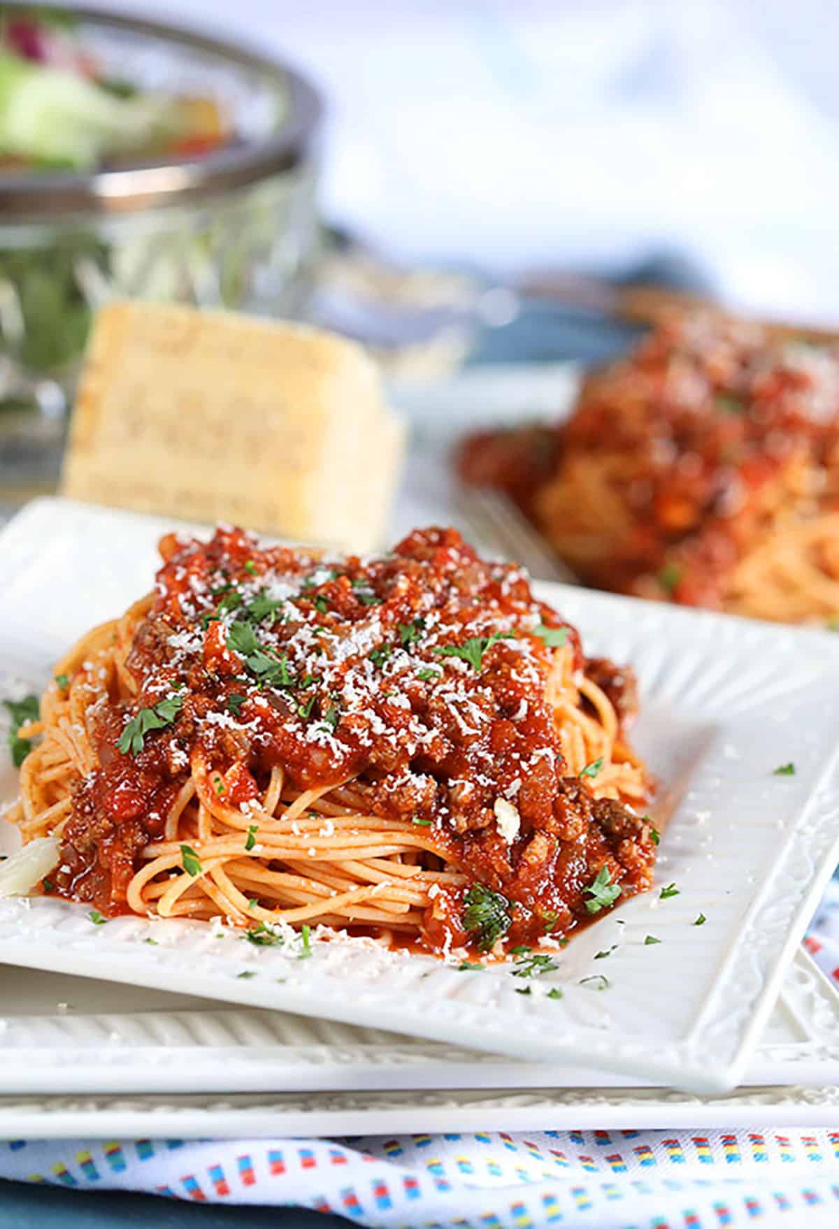 Spaghetti with Easy Italian Meat Sauce on a white plate with a blue background 