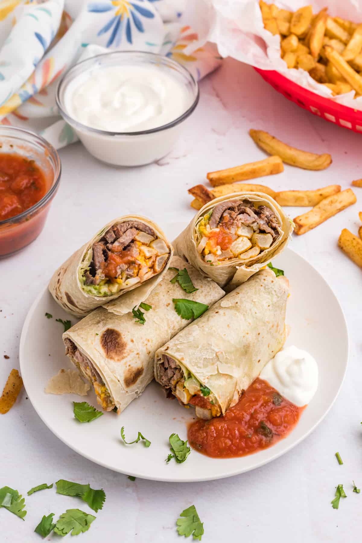 Sliced portions of burritos are placed together on a white plate.