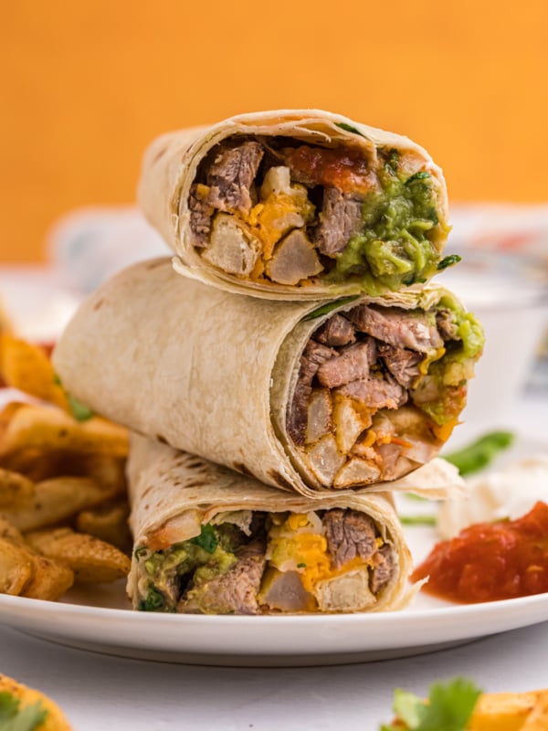 A California burrito is sliced and plated on a white plate.