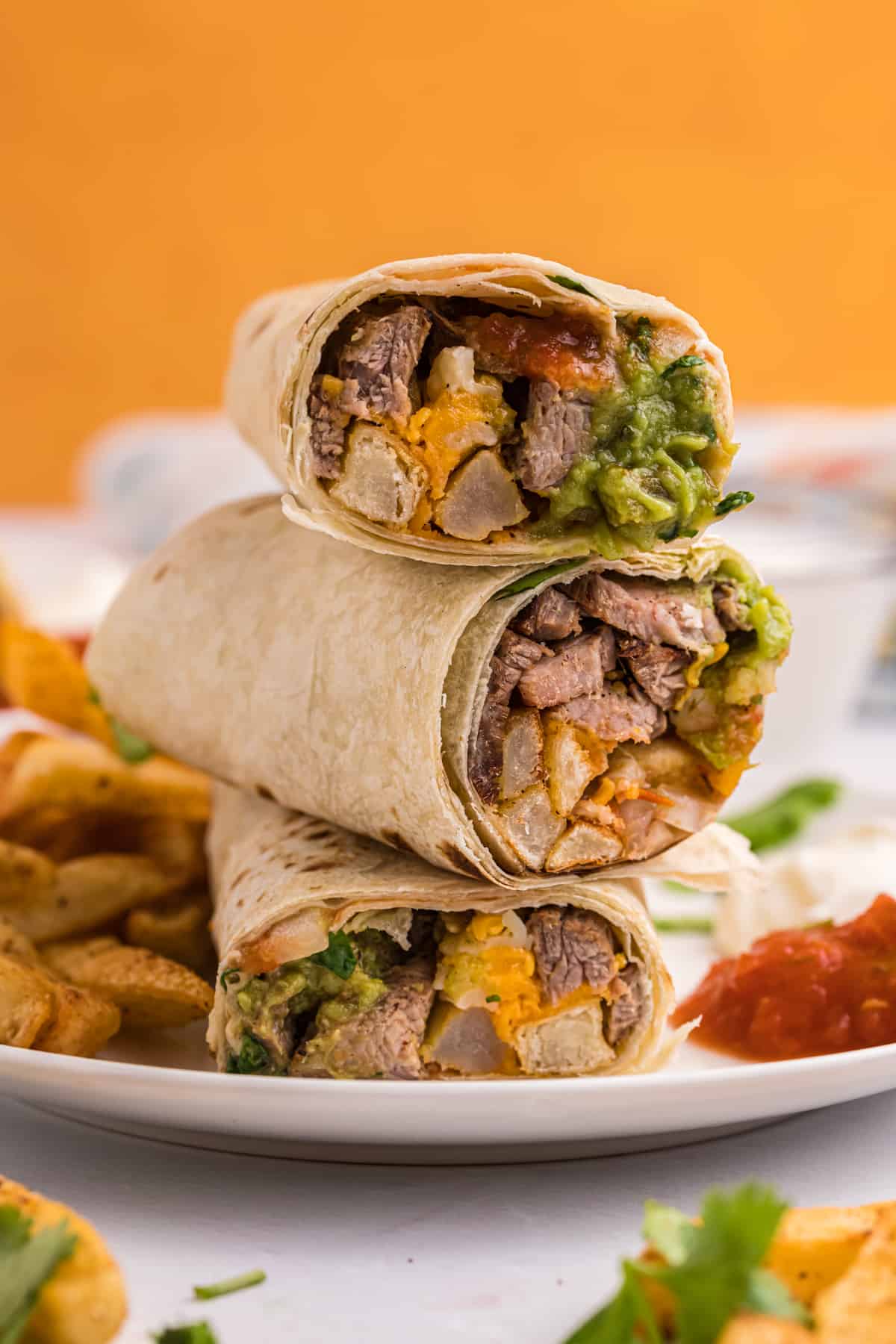 A California burrito is sliced and plated on a white plate.