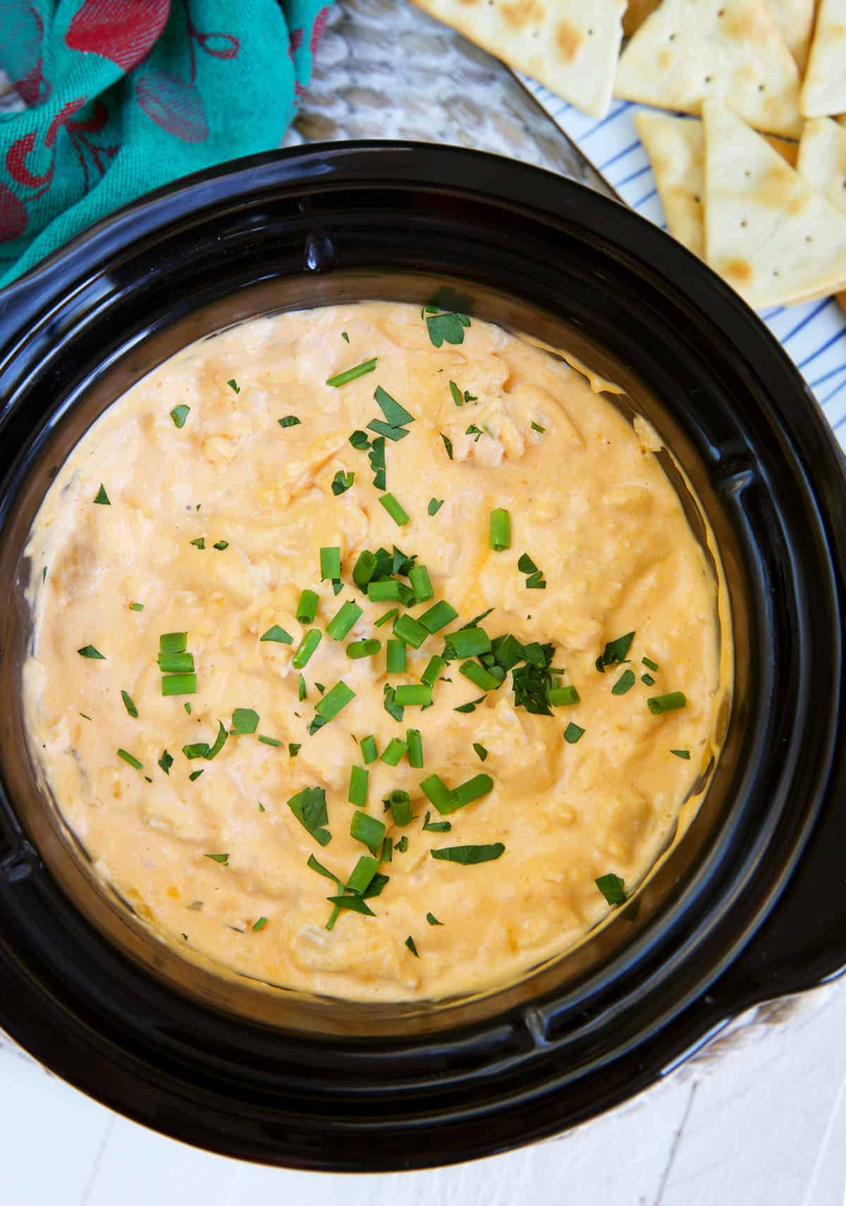 A black crockpot is filled with buffalo dip.