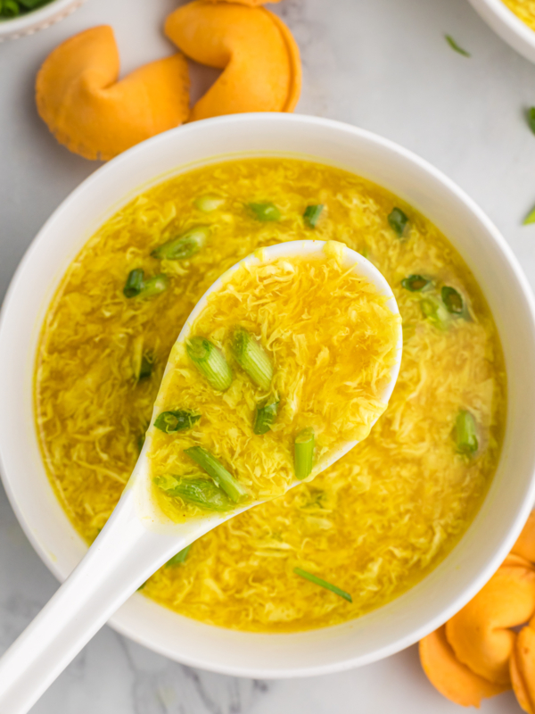 A white bowl is filled with egg drop soup.
