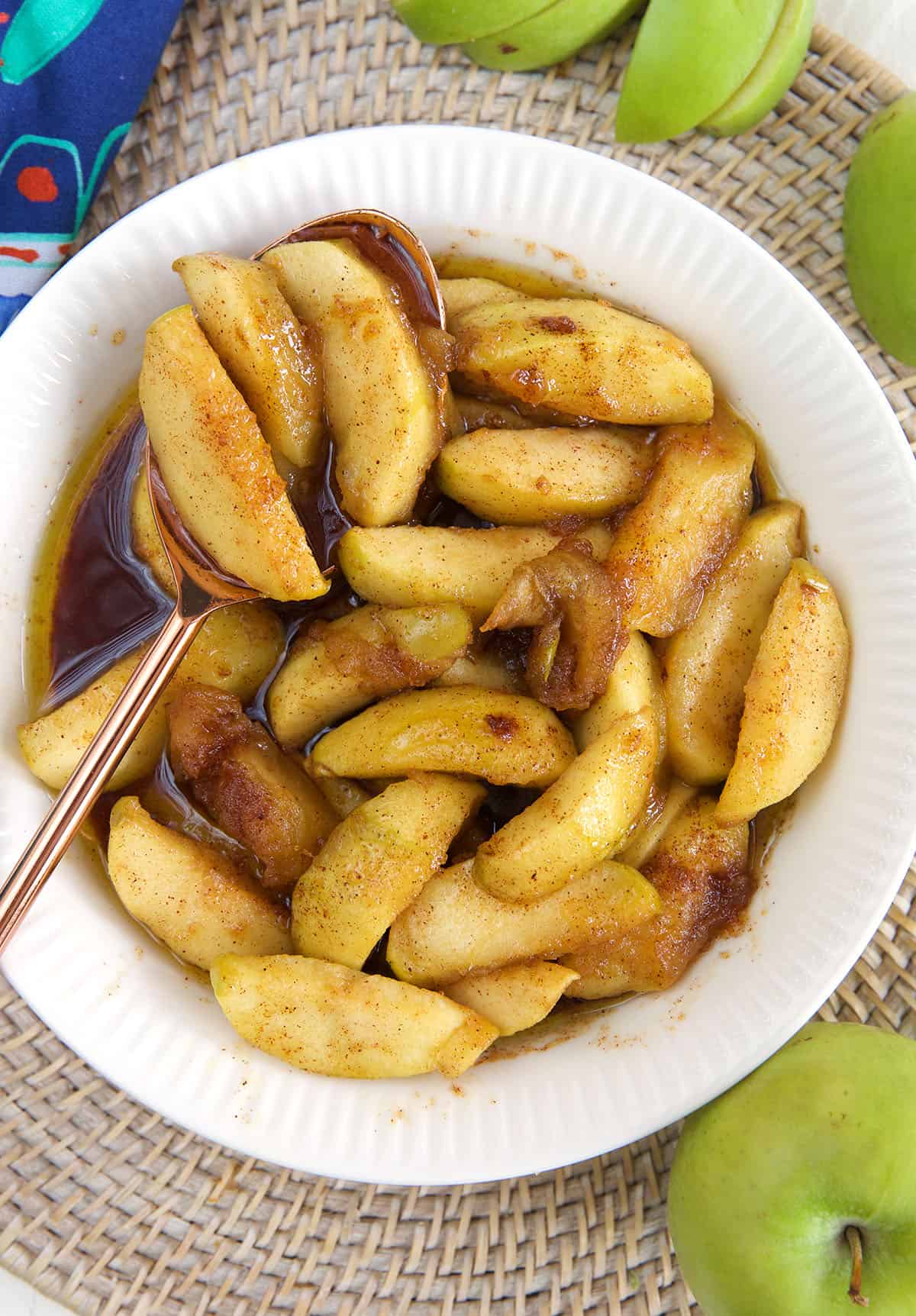 A white bowl is filled with fried apples.
