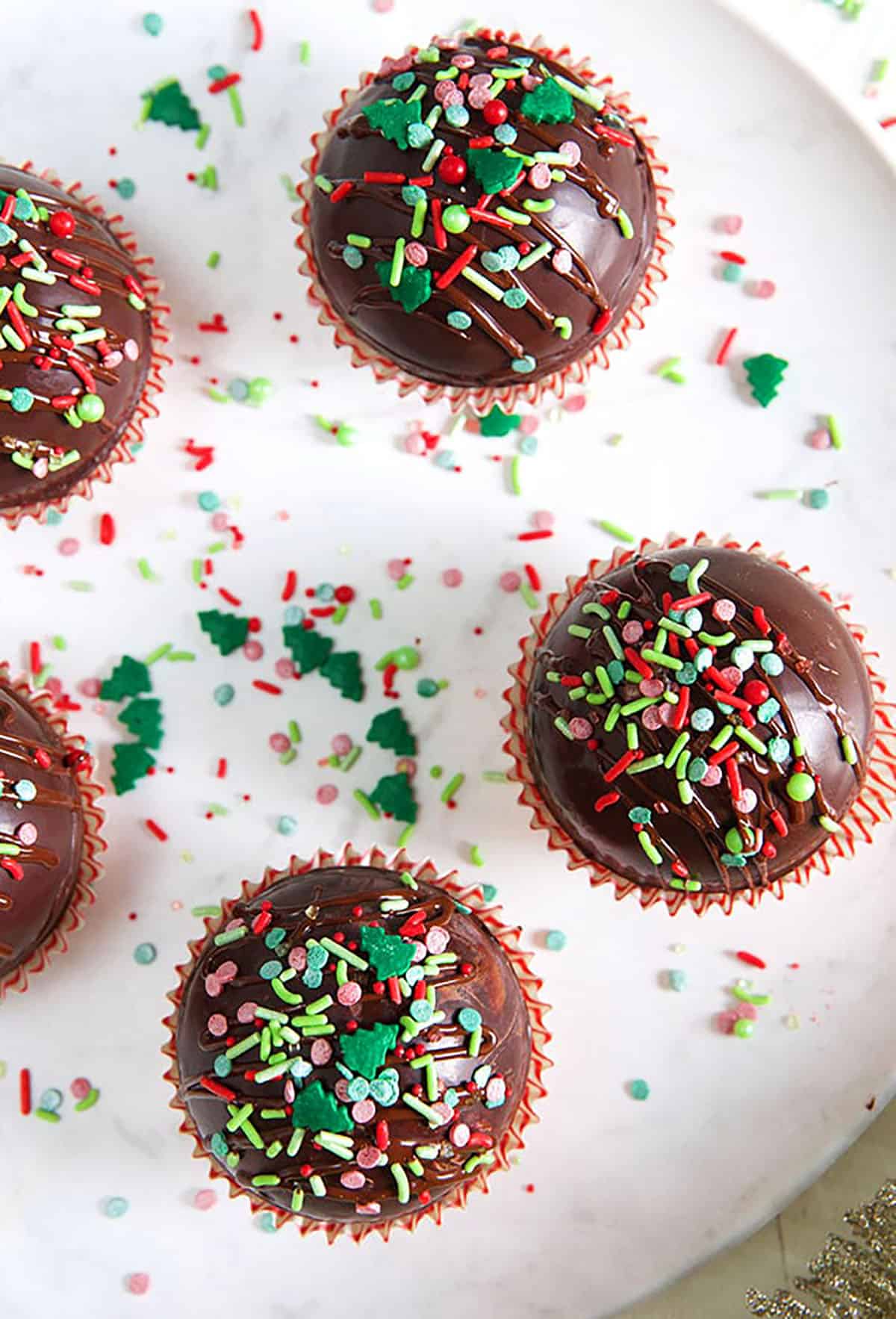 Hot chocolate bombs on a white plate with sprinkles